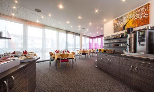 a kitchen and dining room with a table and chairs at Hotel an der Waldstraße in Groß-Zimmern