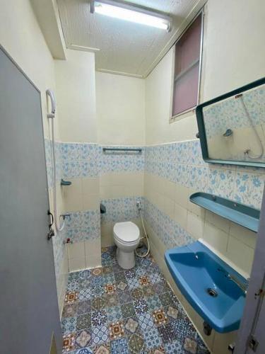 a bathroom with a toilet and a blue sink at Ratanawong Place 507 in Bangkok