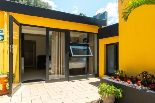 a yellow building with a sliding glass door at Linden Guest House in Johannesburg
