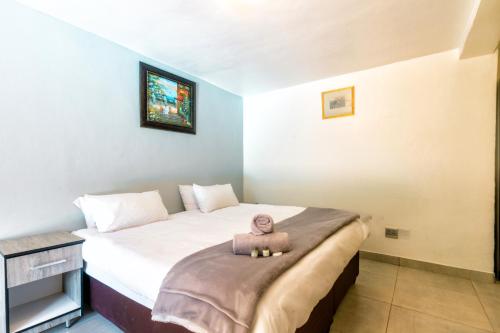 a small bedroom with a bed with a doll on it at Linden Guest House in Johannesburg