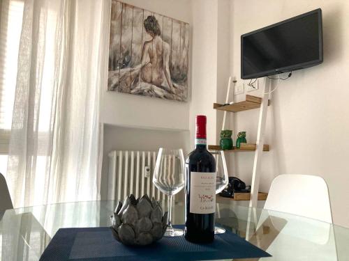 a bottle of wine and a wine glass on a table at Romantic Apartment Verona in Verona