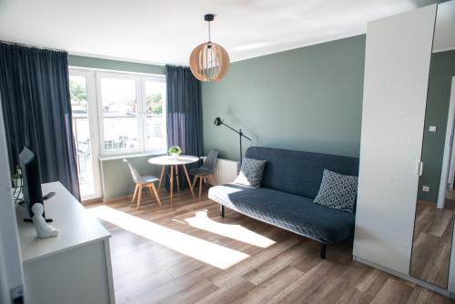 ein Wohnzimmer mit einem blauen Sofa und einem Tisch in der Unterkunft Apartament Monte in Sopot