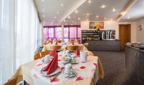 ein Esszimmer mit Tischen und roten Servietten darauf in der Unterkunft Hotel an der Waldstraße in Groß-Zimmern