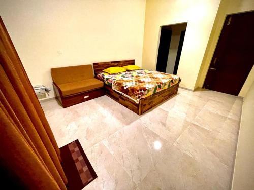 a bedroom with a bed and a couch in a room at Aikya Kadri #Your Home Away from Home# non Smoke# Vegetarians Preferred# Strictly for Families in Mangalore
