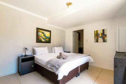 a bedroom with a bed with a teddy bear on it at Linden Guest House in Johannesburg