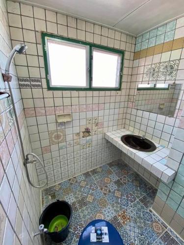 a tiled bathroom with a toilet and a sink at Ratanawong Place 406 in Bangkok