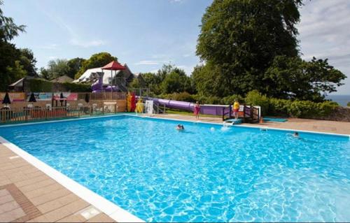 a large blue swimming pool with people in it at Glade 50 Bideford Bay Holiday Park in Bideford