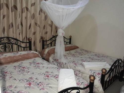 1 dormitorio con 2 camas individuales con red en Talpa Residences. en Tororo