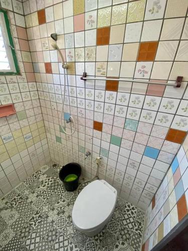 a bathroom with a toilet in a tiled wall at Ratanawong Place 405 in Bangkok