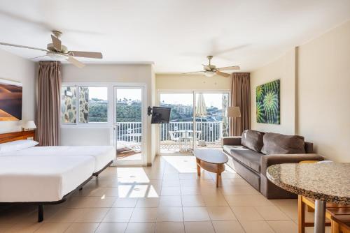 Habitación de hotel con cama y sofá en Hotel Altamadores, en Puerto Rico de Gran Canaria