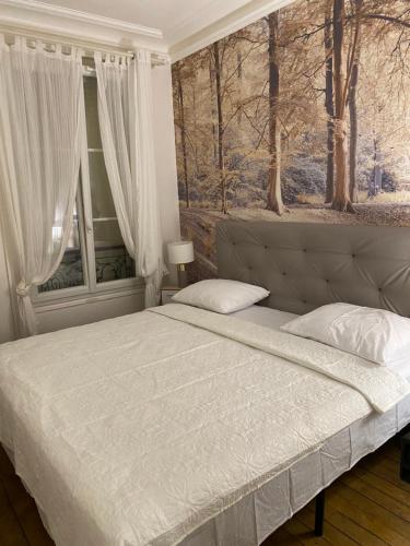 um quarto com uma cama grande e uma janela em Beau 3 pièces à Paris 13 em Paris