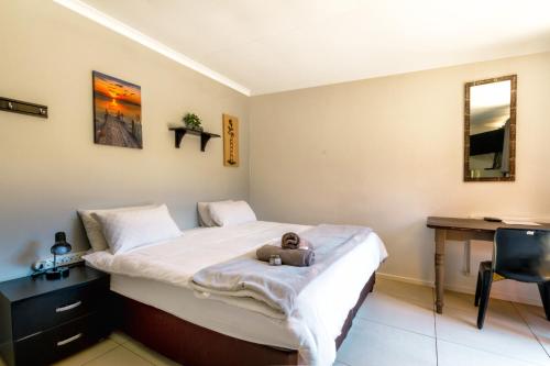 a bedroom with a bed with a teddy bear on it at Linden Guest House in Johannesburg