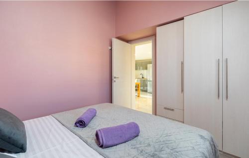 a bedroom with a bed with purple pillows on it at Sunset Vela Luka in Vela Luka