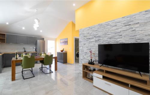 a living room with a large television and a kitchen at Sunset Vela Luka in Vela Luka