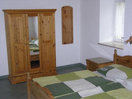 a bedroom with a bed and a wooden cabinet at Ferienwohnung Vordermühle in Bad Schandau