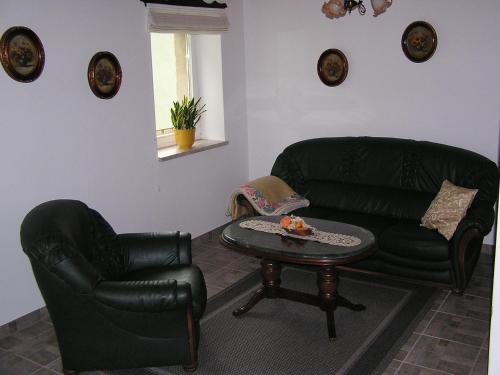a living room with a black leather couch and a table at Ferienwohnung Vordermühle in Bad Schandau
