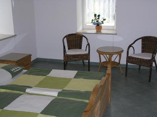a bedroom with a bed and two chairs and a table at Ferienwohnung Vordermühle in Bad Schandau