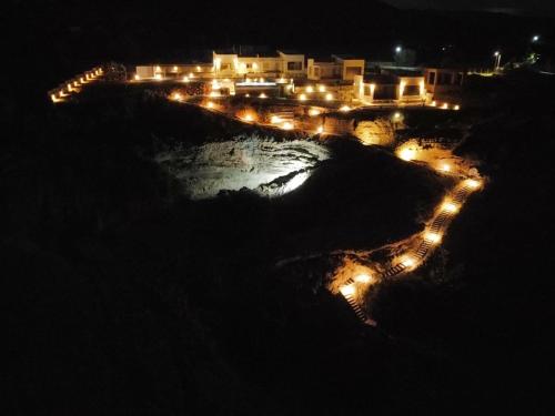 a view of a beach at night with lights at Evgoro - Infinite View in Tsoútsouros
