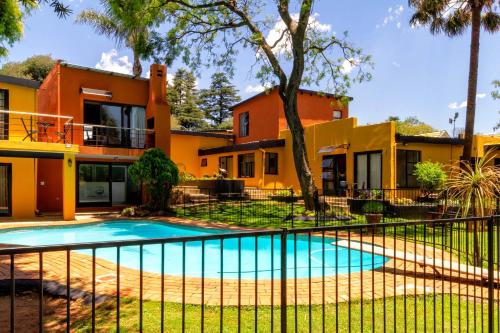 a villa with a swimming pool in front of a house at Linden Guest House in Johannesburg