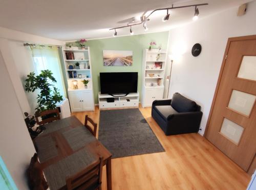 a living room with a television and a couch and a table at Studio / Apartament Sopot zentrum in Sopot