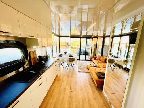 a kitchen and living room with a couch and a table at Hausboot inkl Motorboot, Ostsee in Heiligenhafen