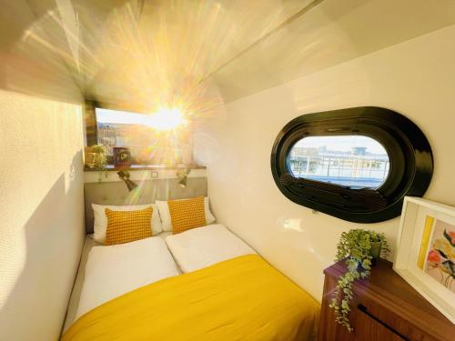 Habitación pequeña con cama y ventana en Hausboot inkl Motorboot, Ostsee, en Heiligenhafen