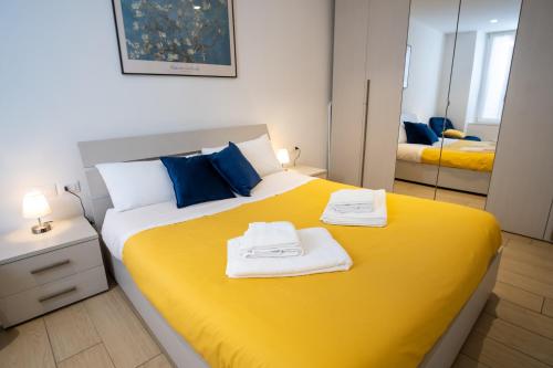 una camera da letto con un letto giallo e asciugamani di Casa vacanza Valentina - Downtown Bergamo a Bergamo