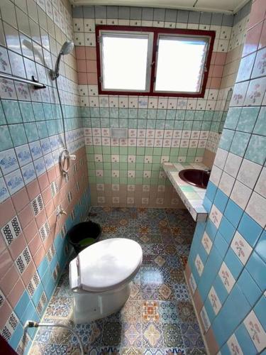 La salle de bains est pourvue de toilettes et d'un lavabo. dans l'établissement Ratanawong Place 304, à Bangkok