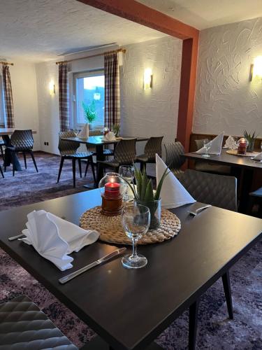 une salle à manger avec une table et un verre de vin dans l'établissement Landgasthof Drei Eichen, à Wilnsdorf