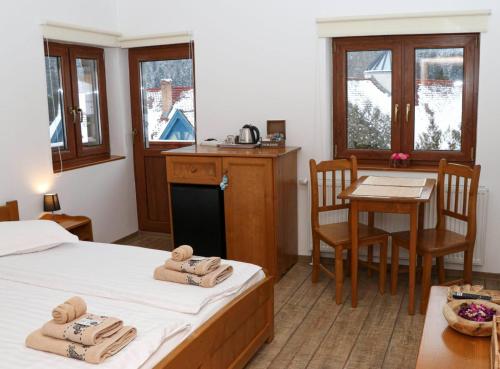 a room with two beds and a table and a kitchen at Casa de oaspeti Kinga's Crown in Băile Tuşnad