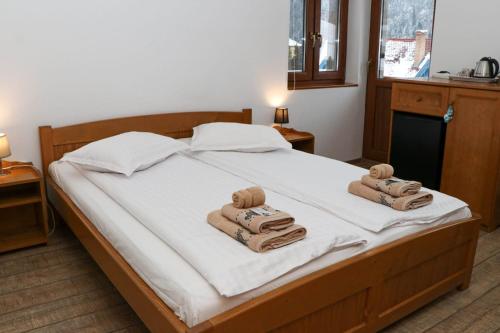 1 dormitorio con 1 cama con toallas en Casa de oaspeti Kinga's Crown en Băile Tuşnad
