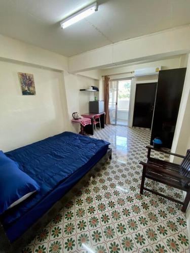 a bedroom with a blue bed and a bench at Ratanawong Place 823 in Bangkok