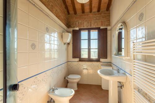 La salle de bains est pourvue d'un lavabo, de toilettes et d'une fenêtre. dans l'établissement Agriturismo S. Eurosia, à Montalcino