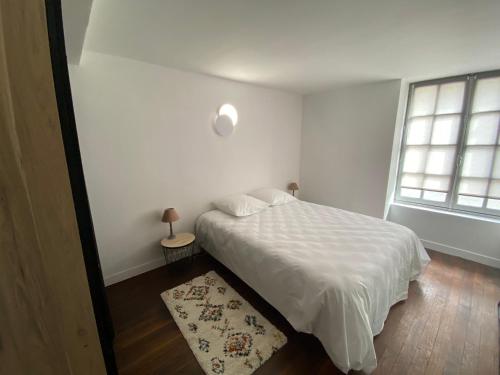 une chambre blanche avec un lit et une fenêtre dans l'établissement * Johnnie Walker * Hypercentre parking *, à Blois