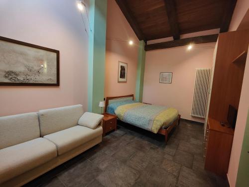 a living room with a couch and a bed at All'Imperatore in Cherasco