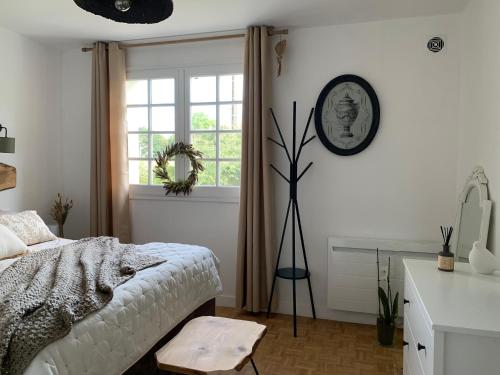 ein Schlafzimmer mit einem Bett und einer Uhr an der Wand in der Unterkunft Le Ch’ti Breizh home in Cléguer