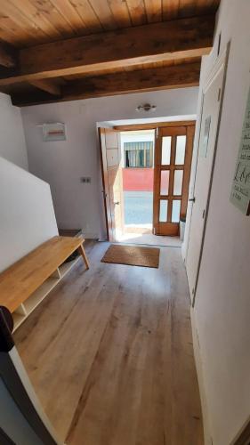 an empty room with a wooden table and a door at La Encina del Abuelo in La Adrada