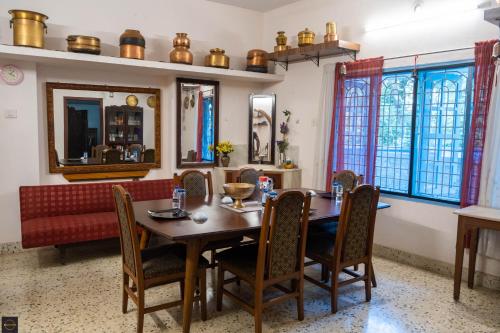 a dining room with a wooden table and chairs at Reunion Pride Villa in Udupi