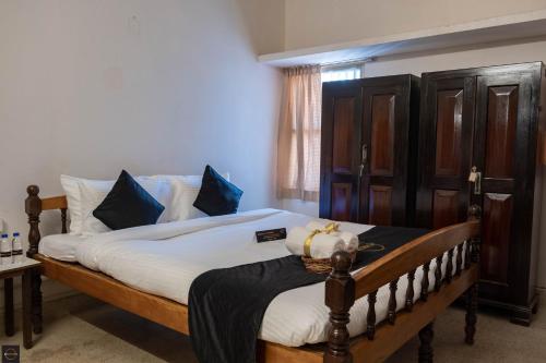 a bedroom with a large bed with blue pillows at Reunion Pride Villa in Udupi