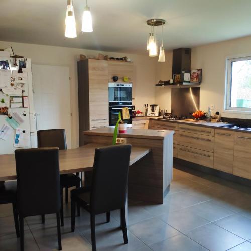 une cuisine avec une table, des chaises et un réfrigérateur dans l'établissement Grande chambre avec salle de bain privative, au Mans