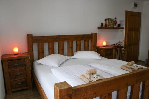 a bedroom with a wooden bed with towels on it at Casa de oaspeti Kinga's Crown in Băile Tuşnad