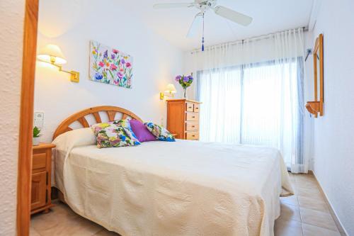 ein Schlafzimmer mit einem Bett, einer Kommode und einem Fenster in der Unterkunft Regata Litoral Costa Dorada - ONLY FAMILIES in Cambrils