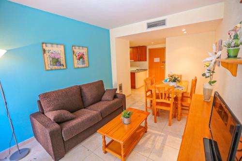 a living room with a couch and a dining room at Sol Millet Litoral - ONLY FAMILIES in Cambrils