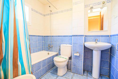 a blue tiled bathroom with a toilet and a sink at Las Brisas I - ONLY FAMILIES in Miami Platja