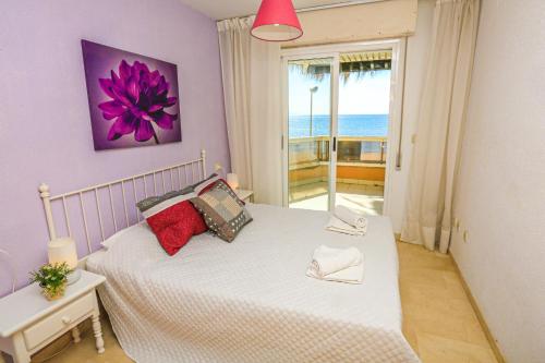 a bedroom with a white bed with a purple wall at Austral - ONLY FAMILIES in Cambrils