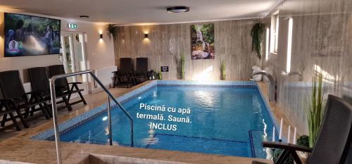 a swimming pool in a house with a sign on it at Motel LAGUNA in Beiuş