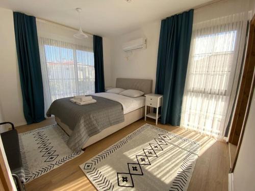 a bedroom with a bed and a large window at Detached villa in Alaçatı… in Alacati
