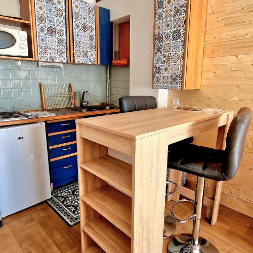 une cuisine avec une table en bois et un comptoir dans l'établissement studio entier 25m2 proche centre ville Font Romeu, à Font-Romeu-Odeillo-Via