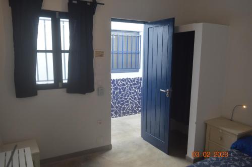 LA VELA في Palmeira: غرفة بها باب أزرق ونافذة