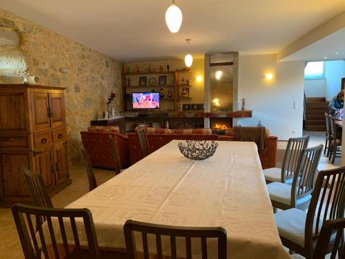 a dining room with a table and chairs and a television at Casa Praia e Campo in Viana do Castelo